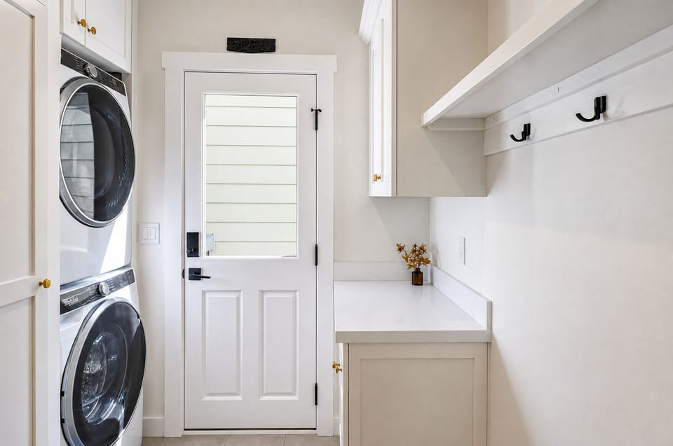 Clean, convenient laundry space with stackable washer and dryer, open shelving for storage, and plenty of counter area to keep your vacation wardrobe fresh and ready.