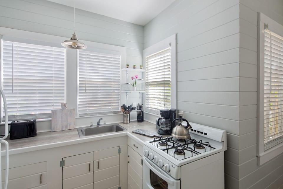 Kitchen includes coffee maker, stove, grill, oven, and toaster.