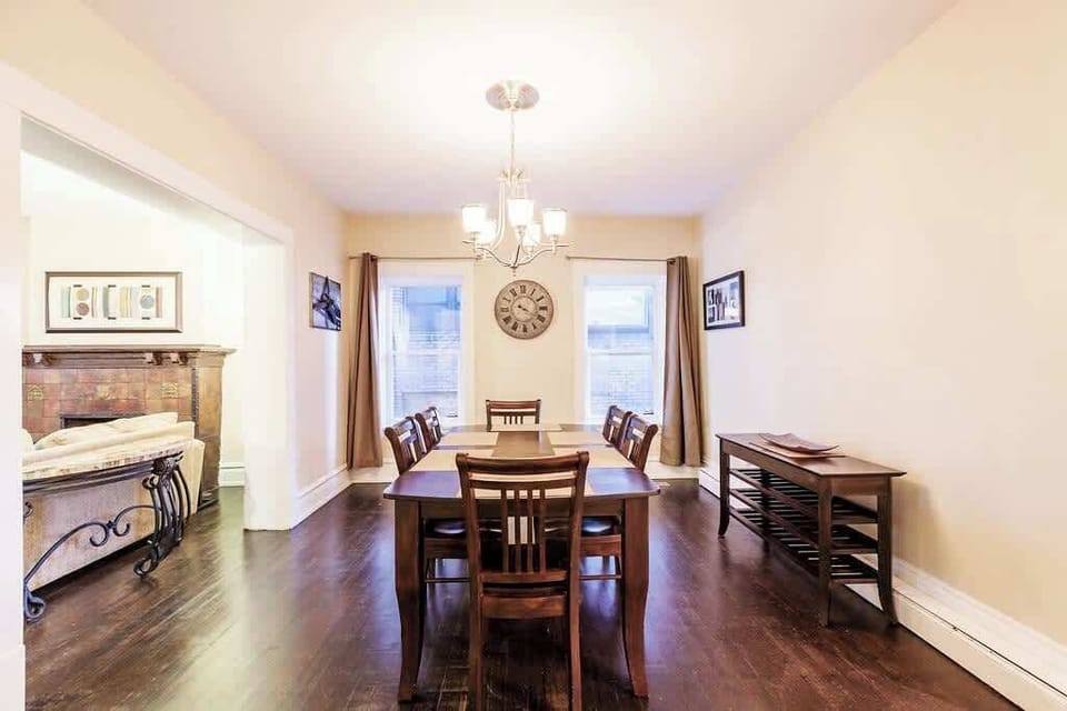 Elegant dining room with a large table, warm lighting, and bright windows—perfect for memorable meals and gatherings.
