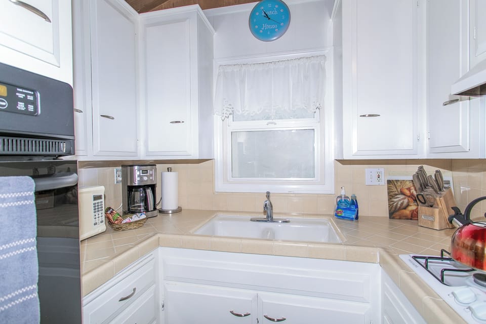 The kitchen is cozy and stocked with all the essentials, including a stove, oven, microwave, and a 12-cup coffee maker. You’ll also find a blender, crockpot, and BBQ utensils ready for your co