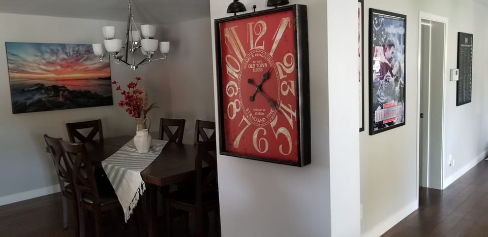 Dining room with media room access and charming red wall clock.