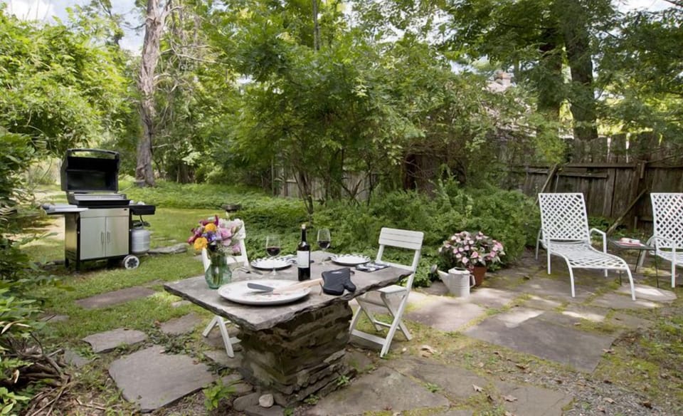 Blue stone patio with a gas grill (Rock City Writer's Studio in background)