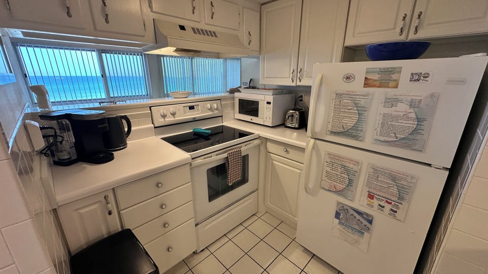 The kitchen has a Keurig coffee maker, an electric kettle, stove, & microwave.