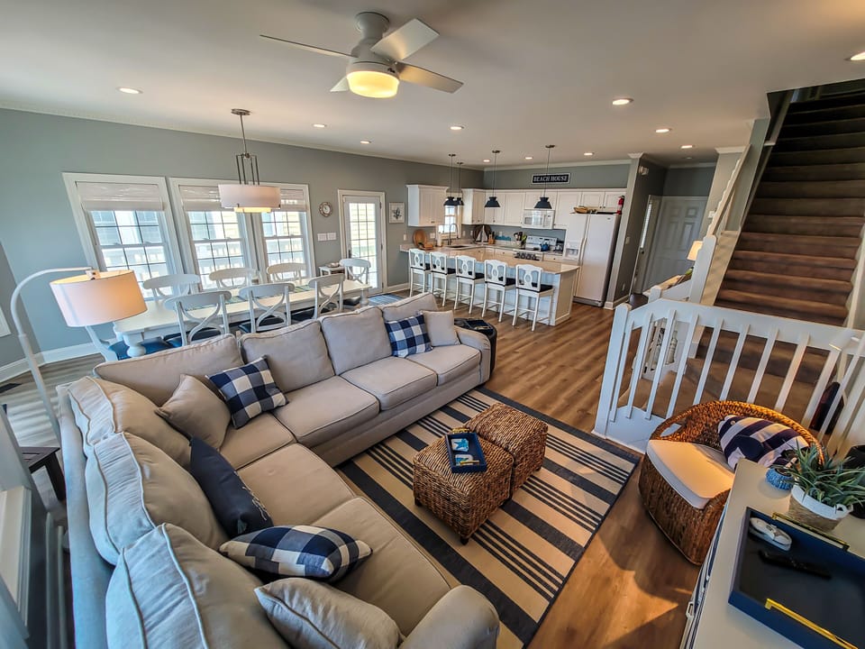 Great room with comfy seating and large dining table and breakfast bar.