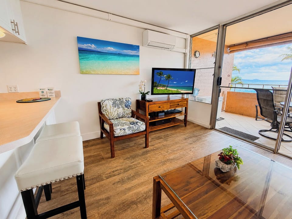 Settle into the tropical-print accent chair with a cold drink in hand and a slice of brilliant blue ocean through the lanai door.
