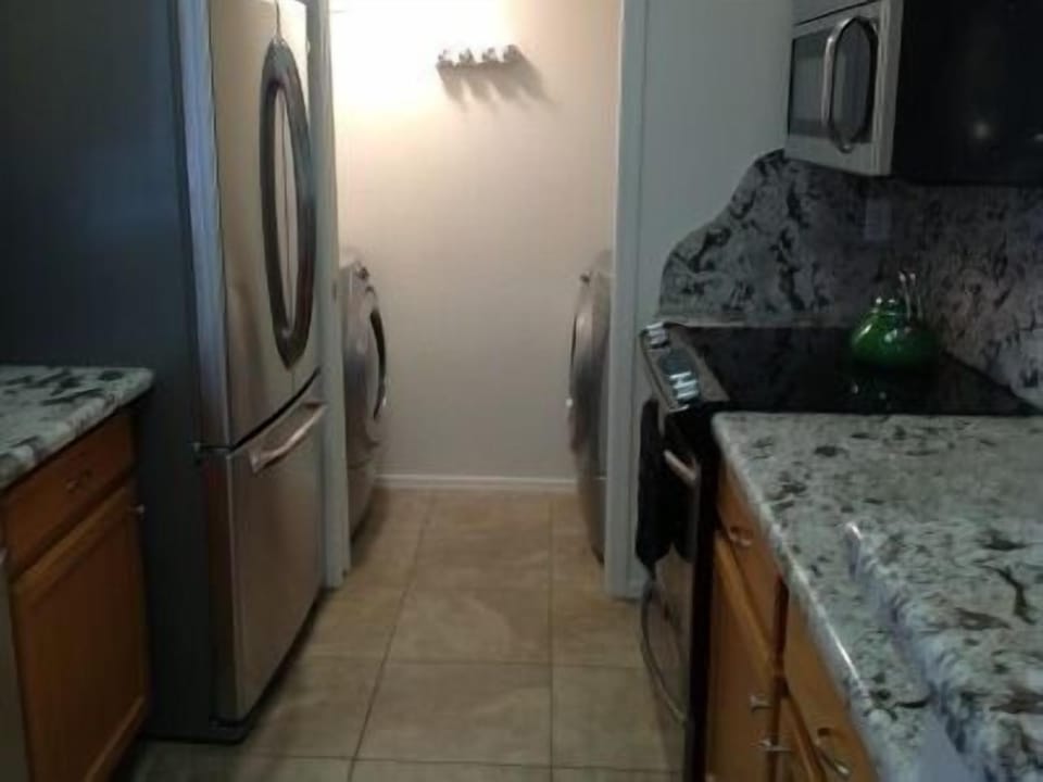 Laundry Room with High Efficiency Washer and Dryer next to Kitchen