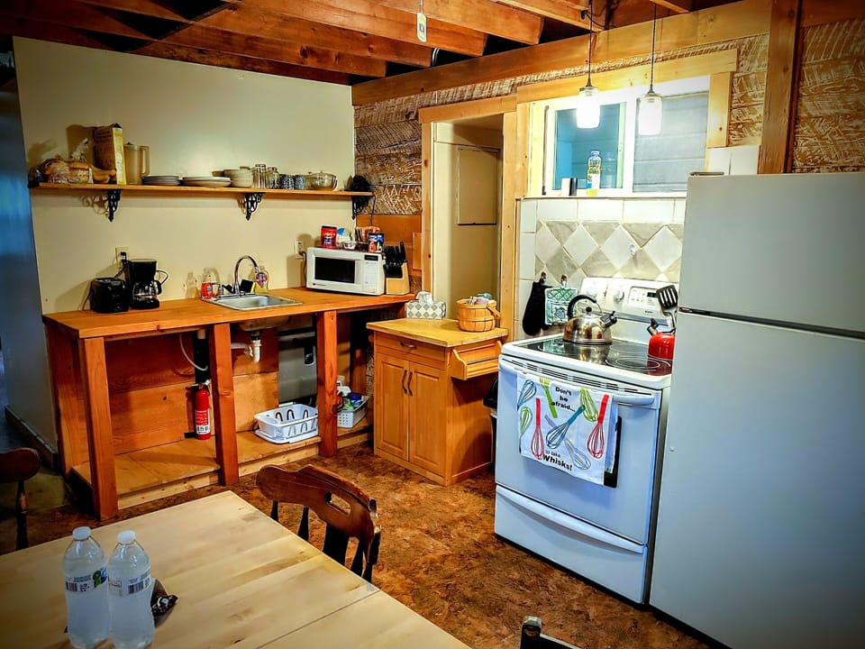 Kitchen includes an electric range, full-size refrigerator,  microwave, and sink