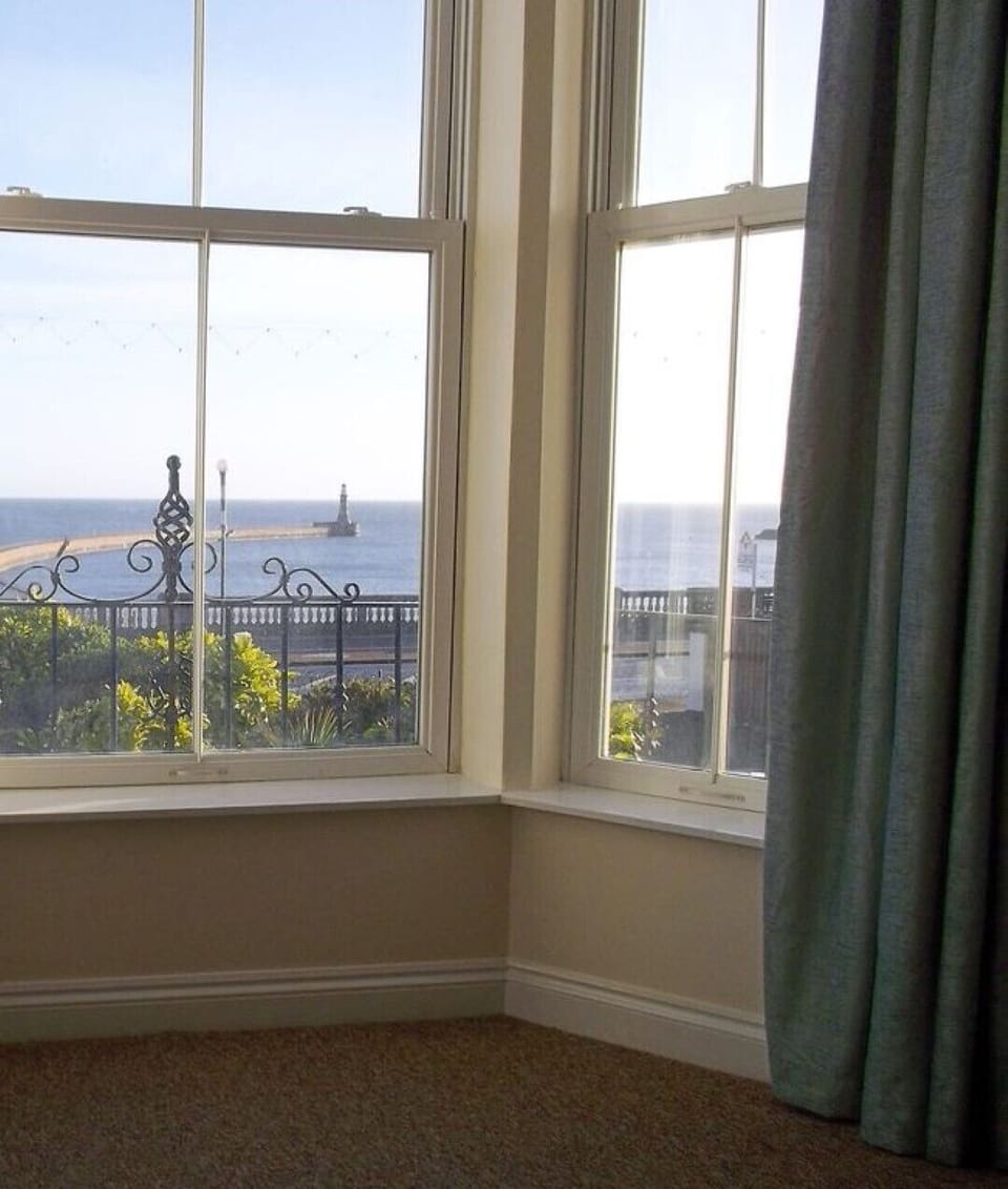 Bay window in lounge area showing view of lighthouse and pier