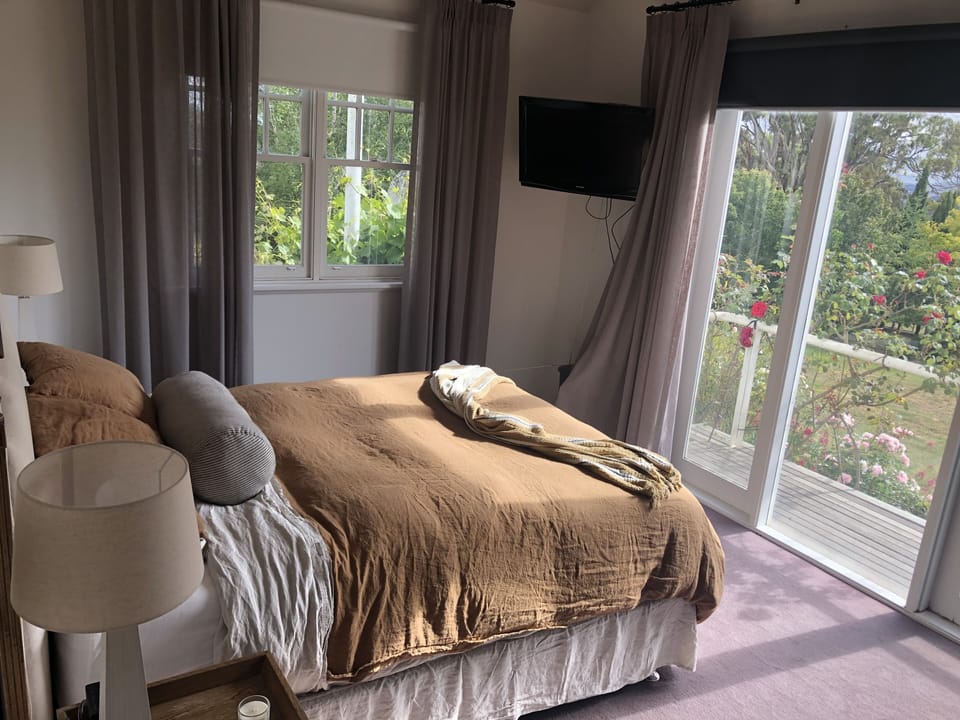 Main Queen Bedroom with deck overlooking garden and valley and rolling hills
