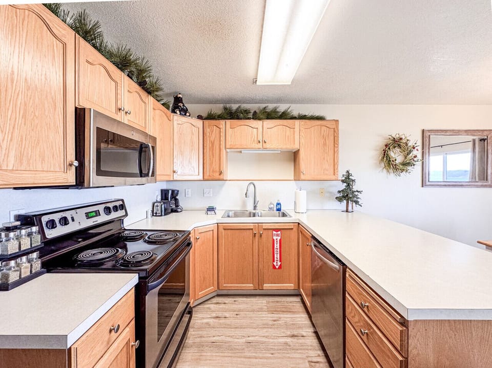 Bright, fully equipped kitchen with ample counter space and warm wood cabinetry
