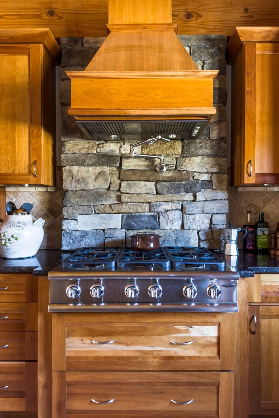 Six burner stove with pot filler faucet.