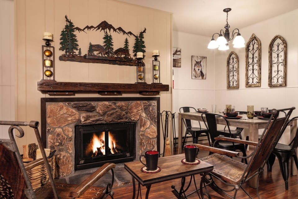 Gather around your cozy fireplace after a day of mountain adventures. This rustic living space invites you to unwind with warm drinks, comfortable seating, and charming mountain-themed décor that makes you feel right at home.