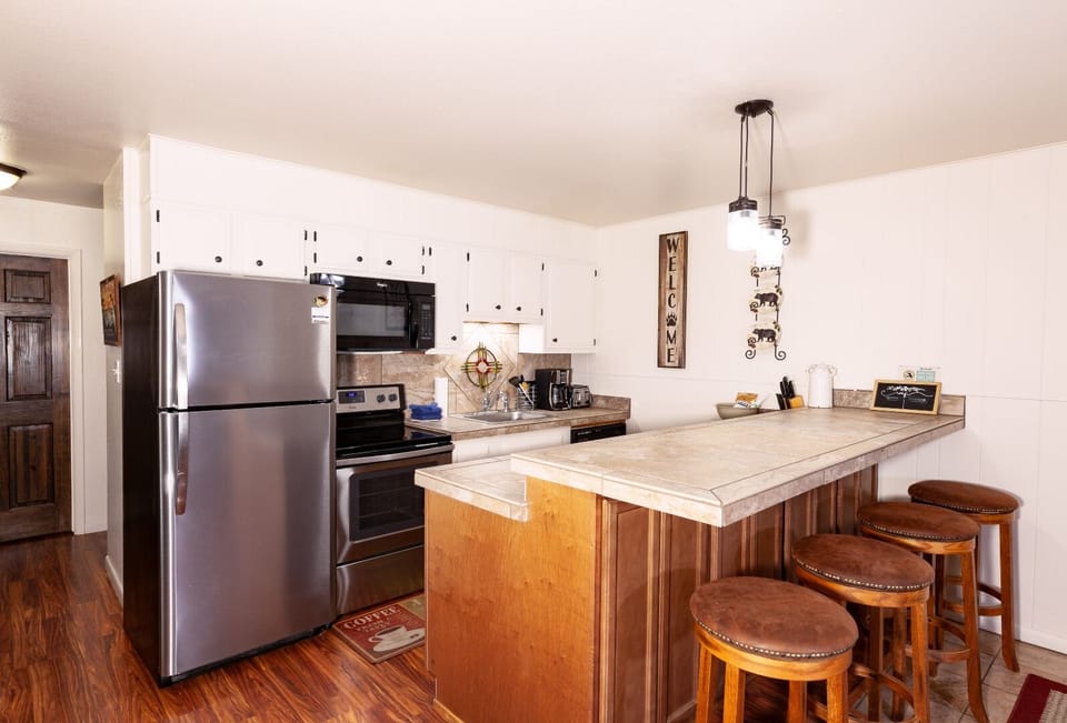 Your fully-equipped kitchen features stainless steel appliances, ample counter space, and a breakfast bar with seating—perfect for preparing meals and gathering together during your stay.