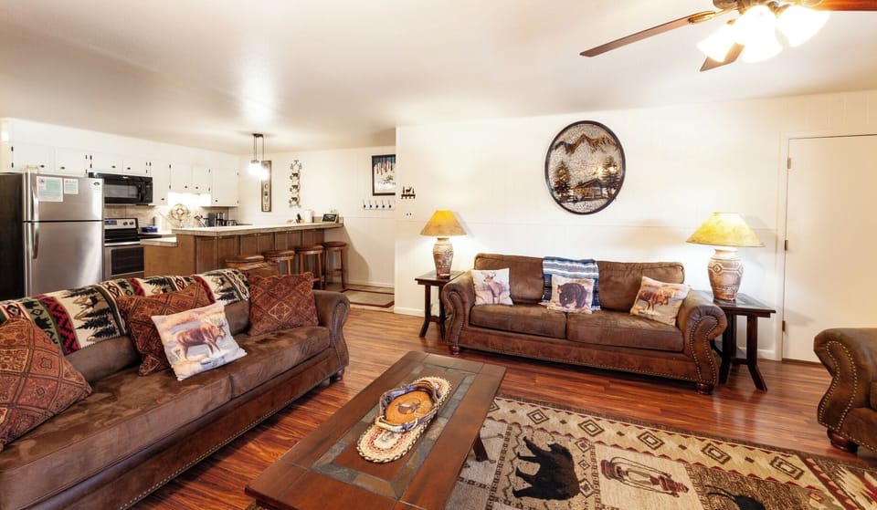 Sink into the plush leather sofas and enjoy your downtime in this welcoming living room, complete with a fully equipped kitchen ready for home-cooked meals.