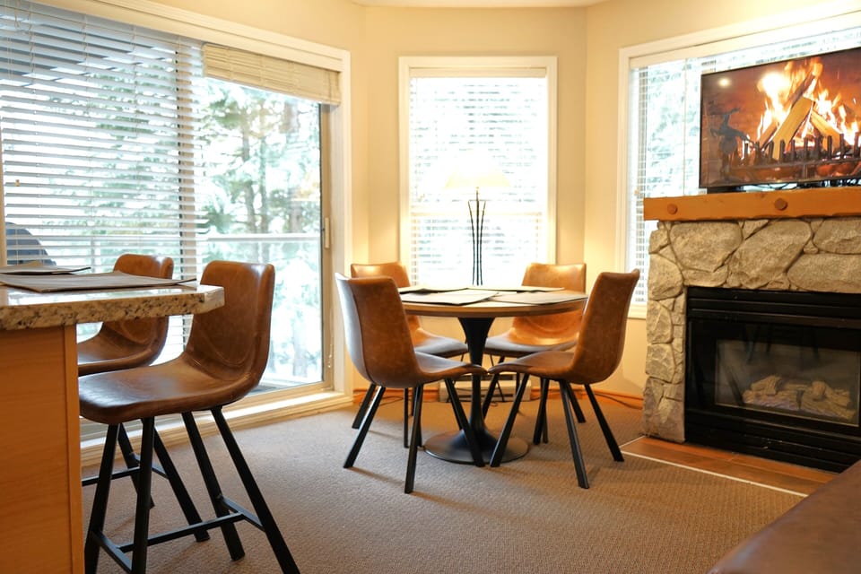 Dining table seats 4, with 3 bar stools along the kitchen counter..