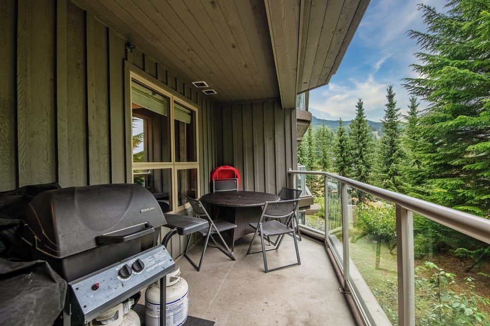 The balcony has a table and a grill for some outdoor cooking.