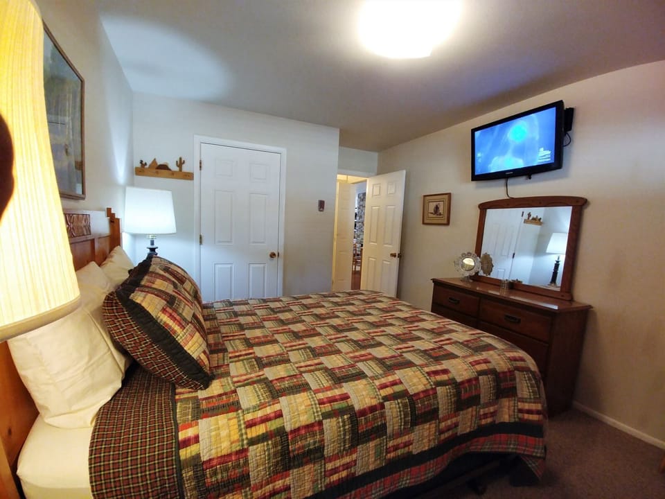Sink into the plush queen bed wrapped in cozy quilted linens, unwind with your favorite shows on the wall-mounted TV, and enjoy the warm, homey ambiance of your private retreat.