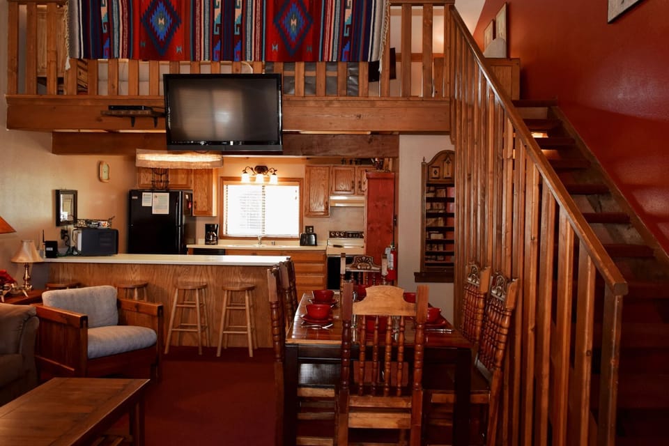 Your cozy loft retreat blends rustic charm with modern convenience—warm wood accents, a fully equipped kitchen, inviting dining space, and a lofted sleeping area create your perfect mountain escape.