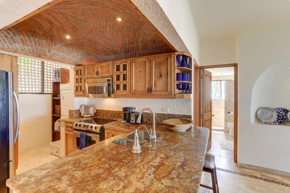 Kitchen has a beautiful brick ceiling and laundry enclave.