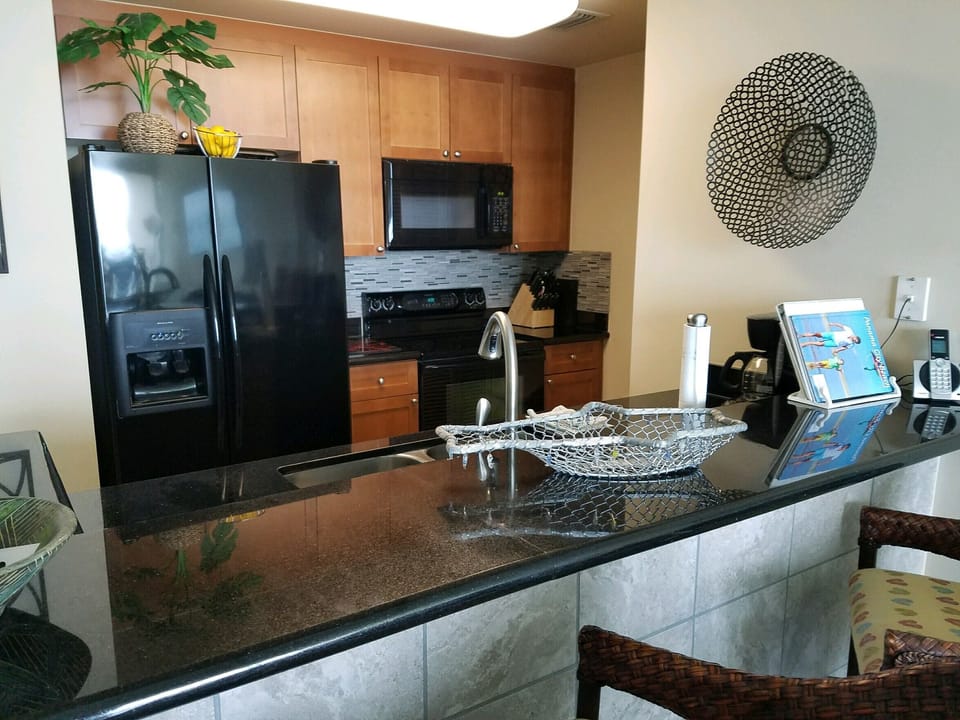 New black appliances and black granite countertops. 