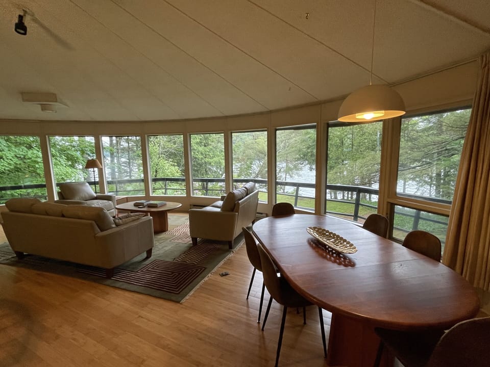 Living and dining area on the upper level with a wall of windows at bird height!