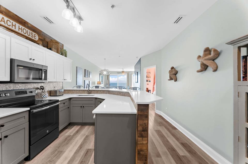View of the open-concept kitchen, dining, and living area, designed for effortless flow, comfortable gathering, and relaxed coastal living.
