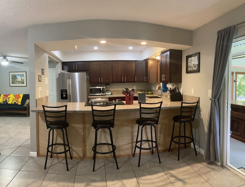 Kitchen and bar with sliding glass door to screened lanai