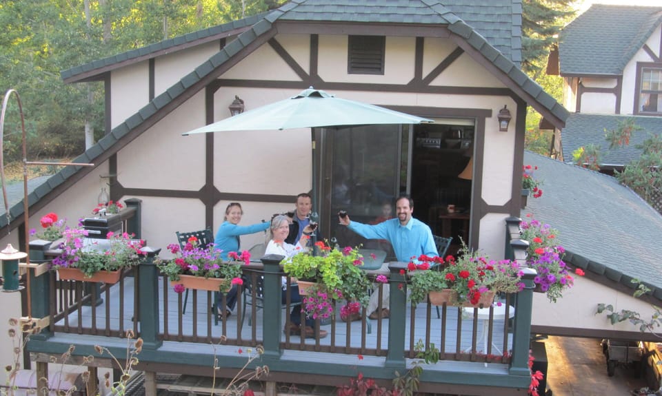 Couples enjoying a glass of wine on  2nd story private deck.  Flowers galore.