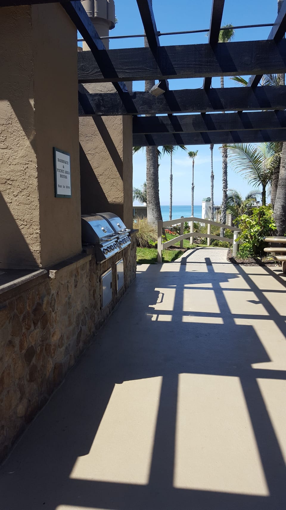 Community BBQ area with picnic tables and ocean view.