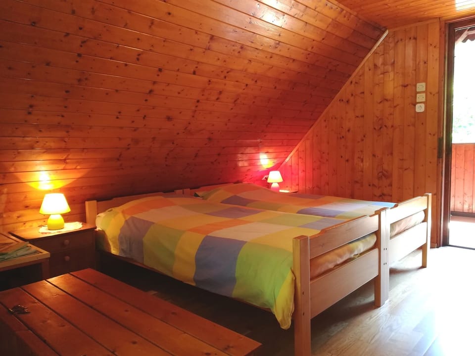 King bed with spelt pillows in the attic and balcony deck chairs with a view.