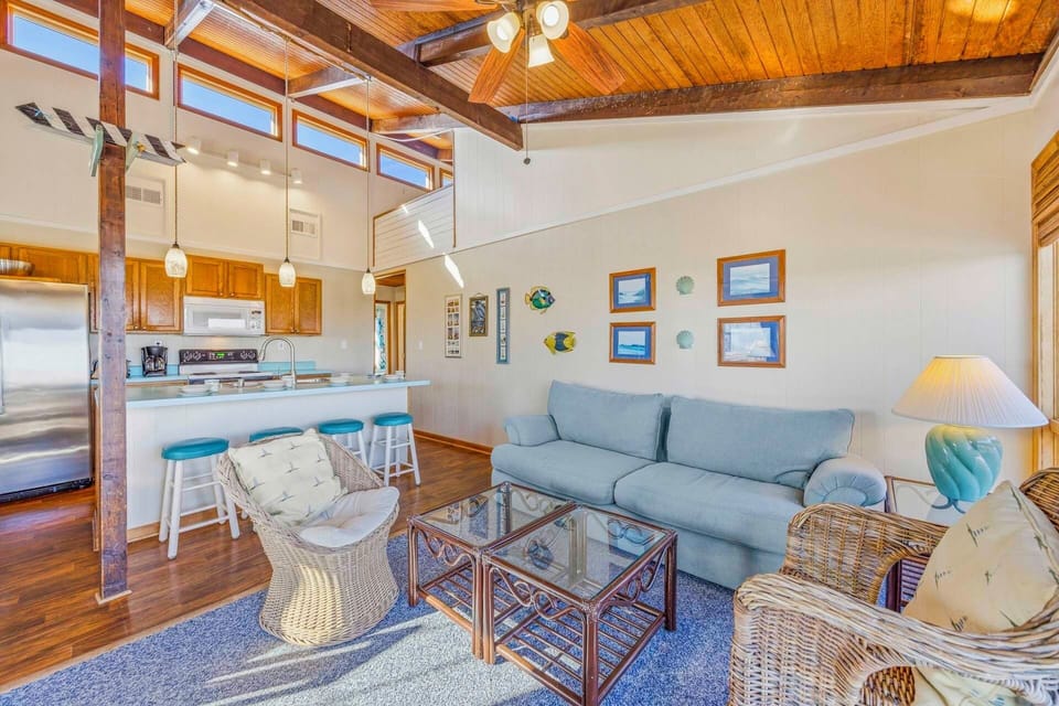 Your open-concept living space combines comfort with character, featuring exposed beams and a cozy sofa perfect for relaxing after adventures.