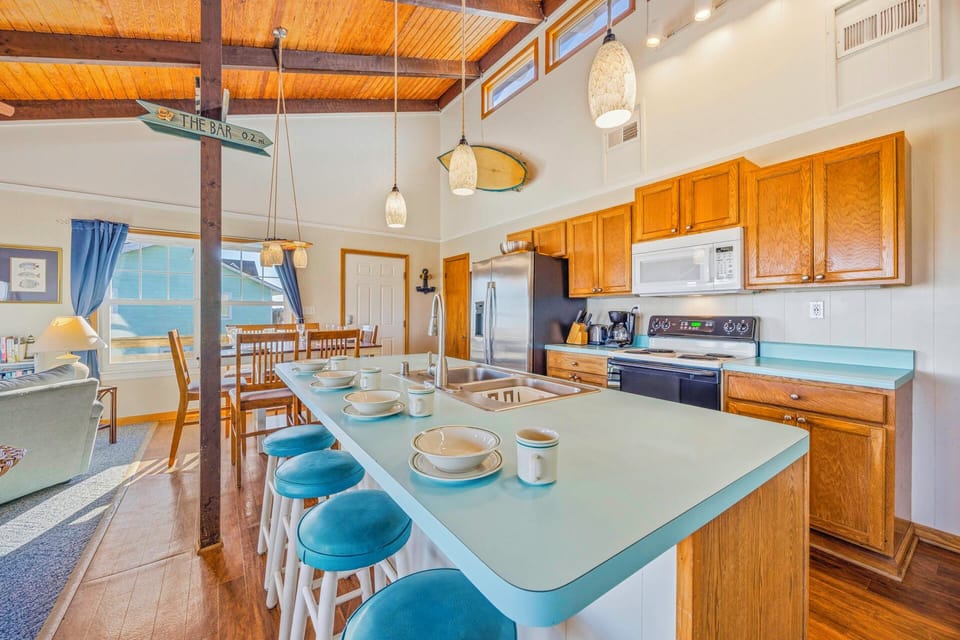 Your spacious kitchen island invites morning coffee and meal prep, while exposed beams and nautical touches create a cozy coastal atmosphere.