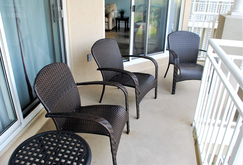 The balcony, which features four chairs and a small table.
