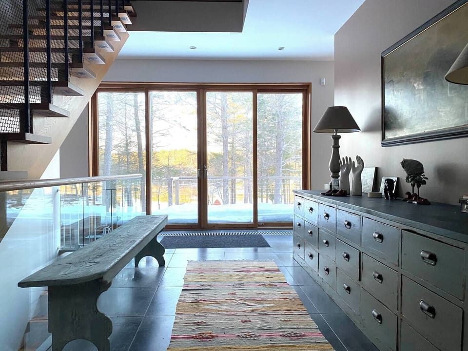 A bright entry hallway with floor-to-ceiling windows welcomes you with direct water views.