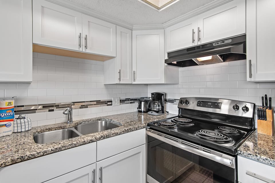 Fully equipped kitchen with stove, microwave, dishwasher, and utensils.
