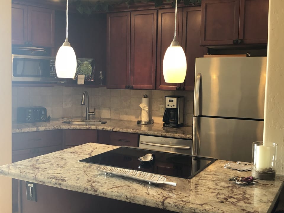 The kitchen has a dishwasher, range with oven and microwave