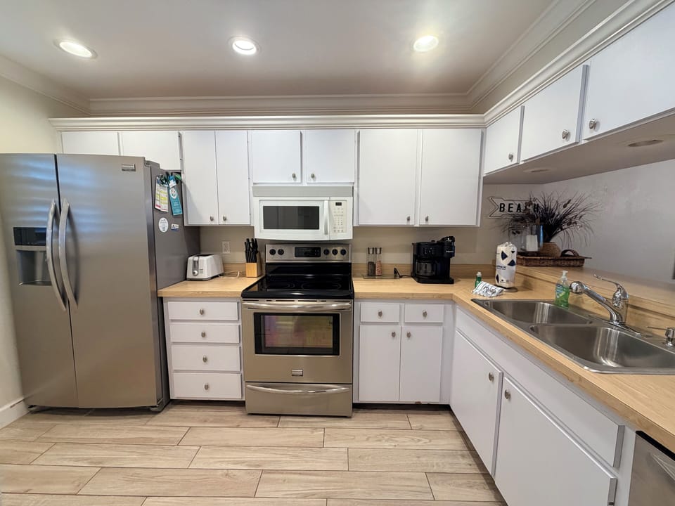 Your fully equipped kitchen features stainless steel appliances, ample counter space, and crisp white cabinetry—perfect for whipping up morning coffee or preparing a home-cooked meal during your stay.