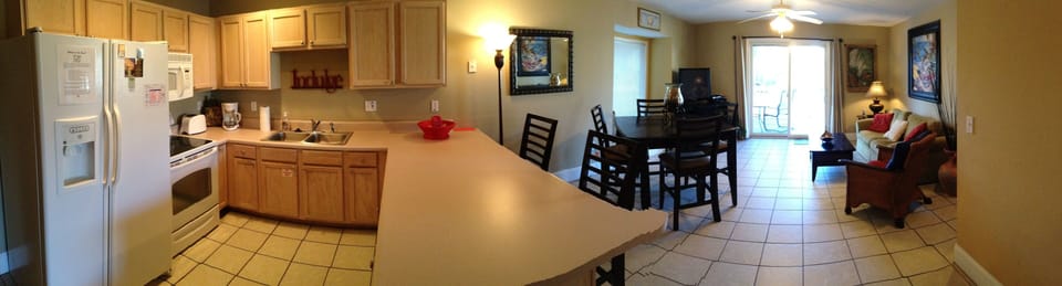 Panoramic view of kitchen, dining area and living room from second bedroom
