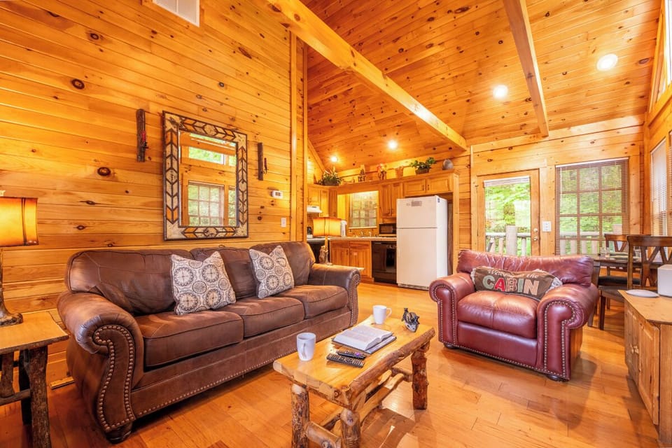 Sink into plush leather seating by the glowing fireplace, where rustic charm and soaring ceilings create your perfect mountain escape.