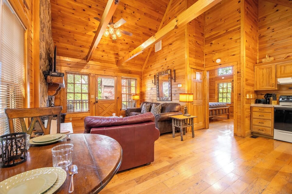 Unwind in your cozy cabin retreat, where warm wood tones and vaulted ceilings create an inviting atmosphere. Plush leather seating and soft lamplight set the stage for relaxation after a day exploring.
