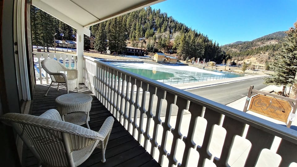 Your private balcony opens to a stunning mountain setting, where pine-covered slopes frame a peaceful alpine scene. Relax in cozy wicker seating and soak in the fresh air and natural beauty.