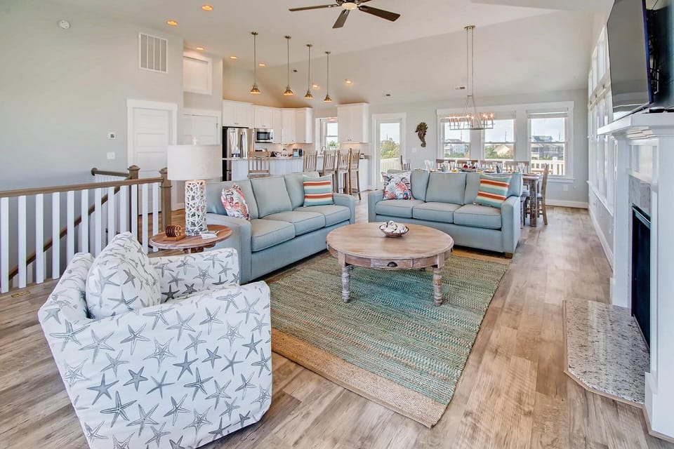 Unwind in this bright, open-concept living space where soft coastal hues and comfortable seating invite you to relax after a day exploring. The adjoining kitchen and dining areas make gathering with loved ones effortless.