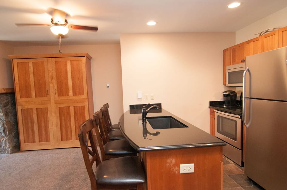 Kitchen with granite counters & stainless steel appliances, murphy bed