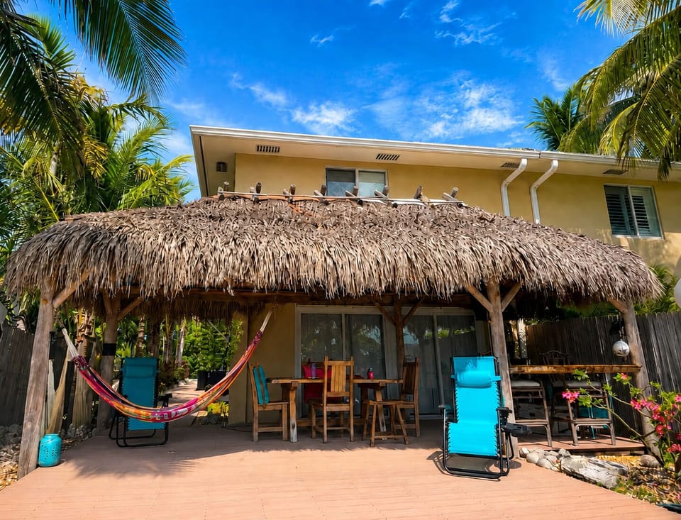 Shaded tiki hut with hammocks & outdoor dining—perfect for relaxing. 💖🌴