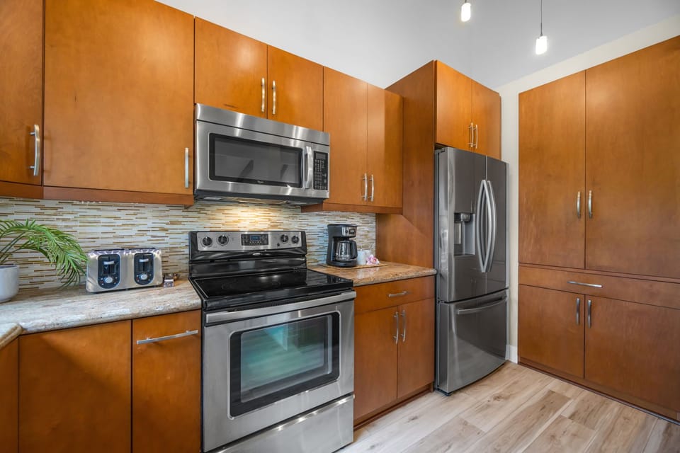 Cook with ease in a modern kitchen equipped with sleek stainless steel appliances, polished countertops, and ample storage.