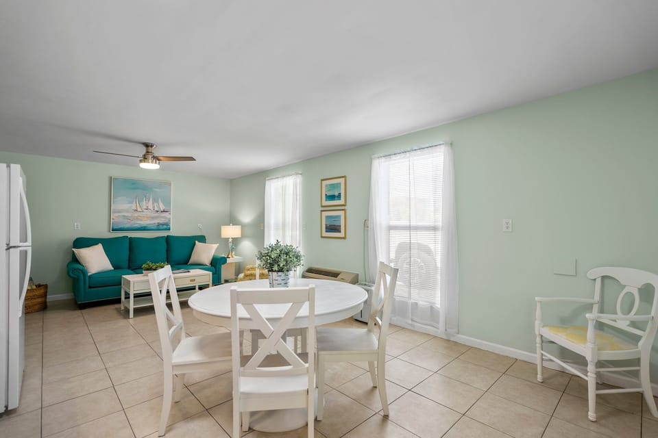 Unwind in your bright, coastal-themed living space where soft mint walls and nautical artwork create a serene seaside retreat.
