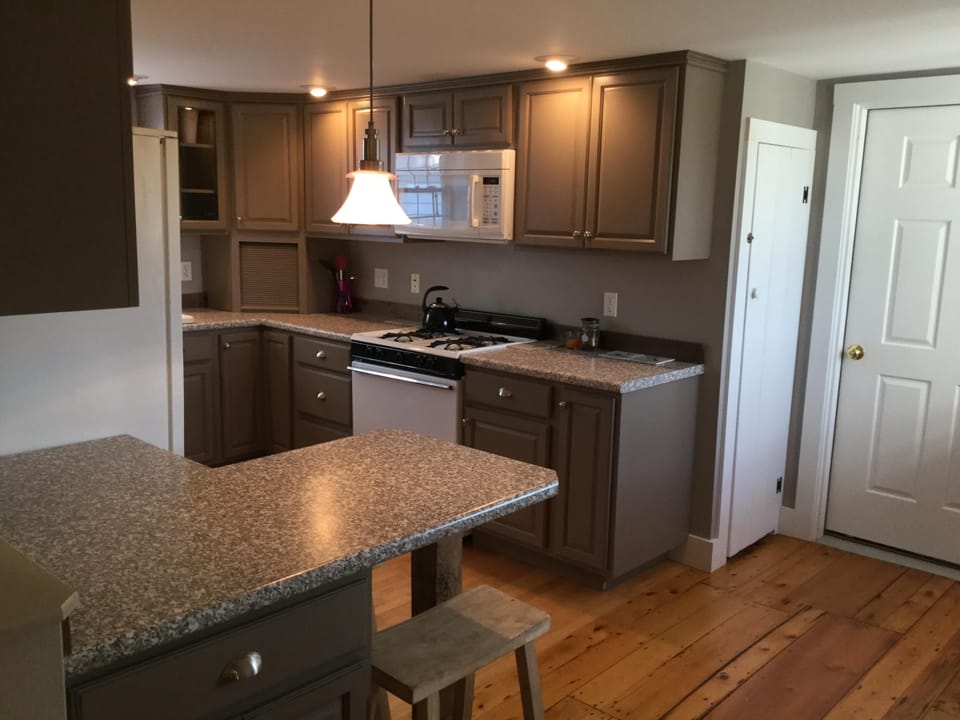 Kitchen from the living room, showing the fridge, stove, microwave, & peninsula.
