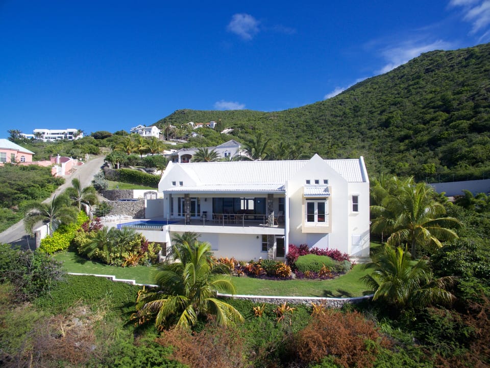 Drone shot of front of Seas The Moment. Sandy beach is 2-3 min walk down hill.