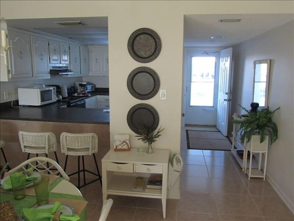 Condo entry and view of kitchen through pass through bar
