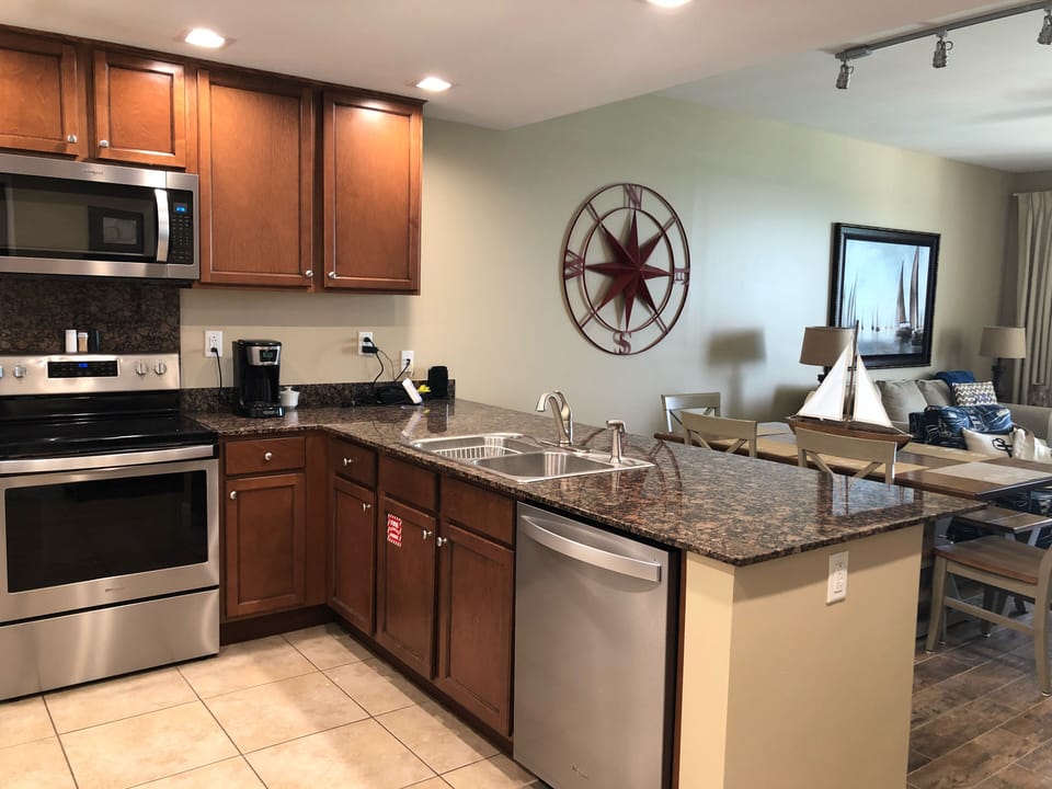 Large kitchen area with granite countertops and stainless steel appliances.  